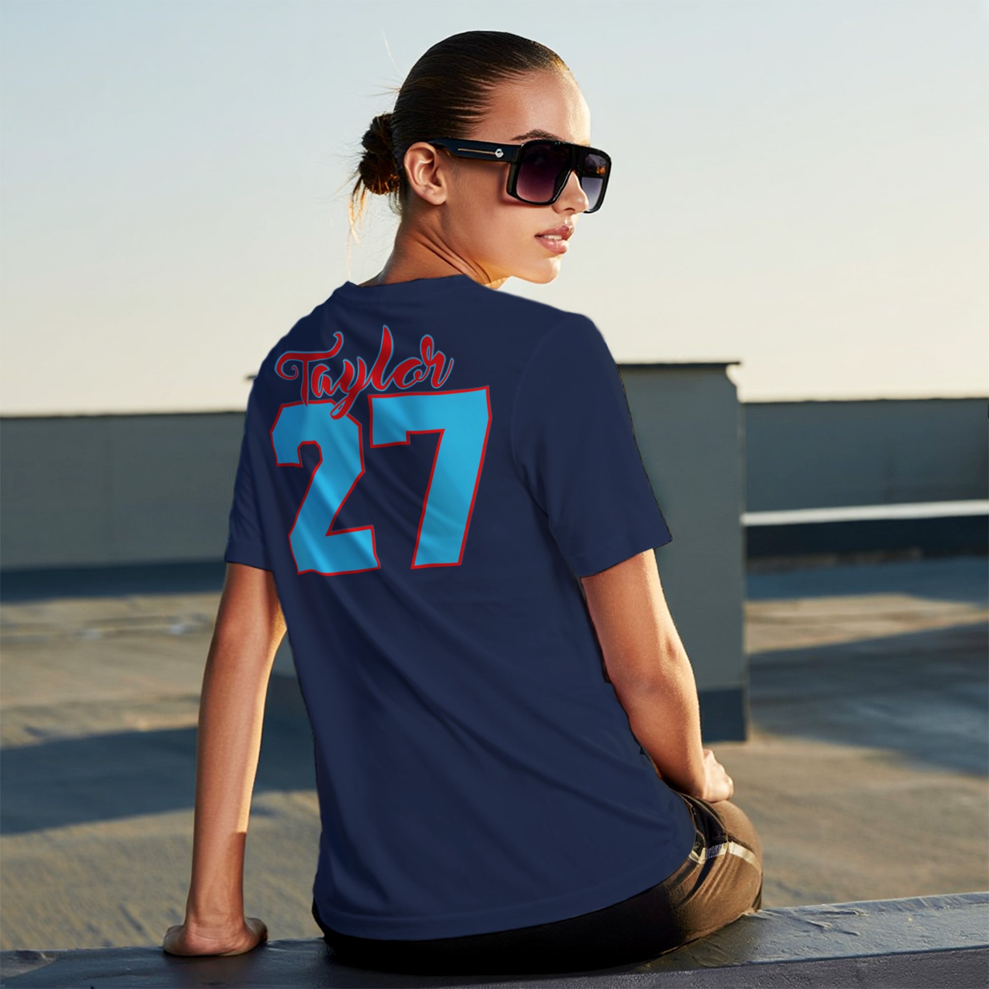 Person wearing a navy blue t-shirt with 'Taylor 27' on the back
