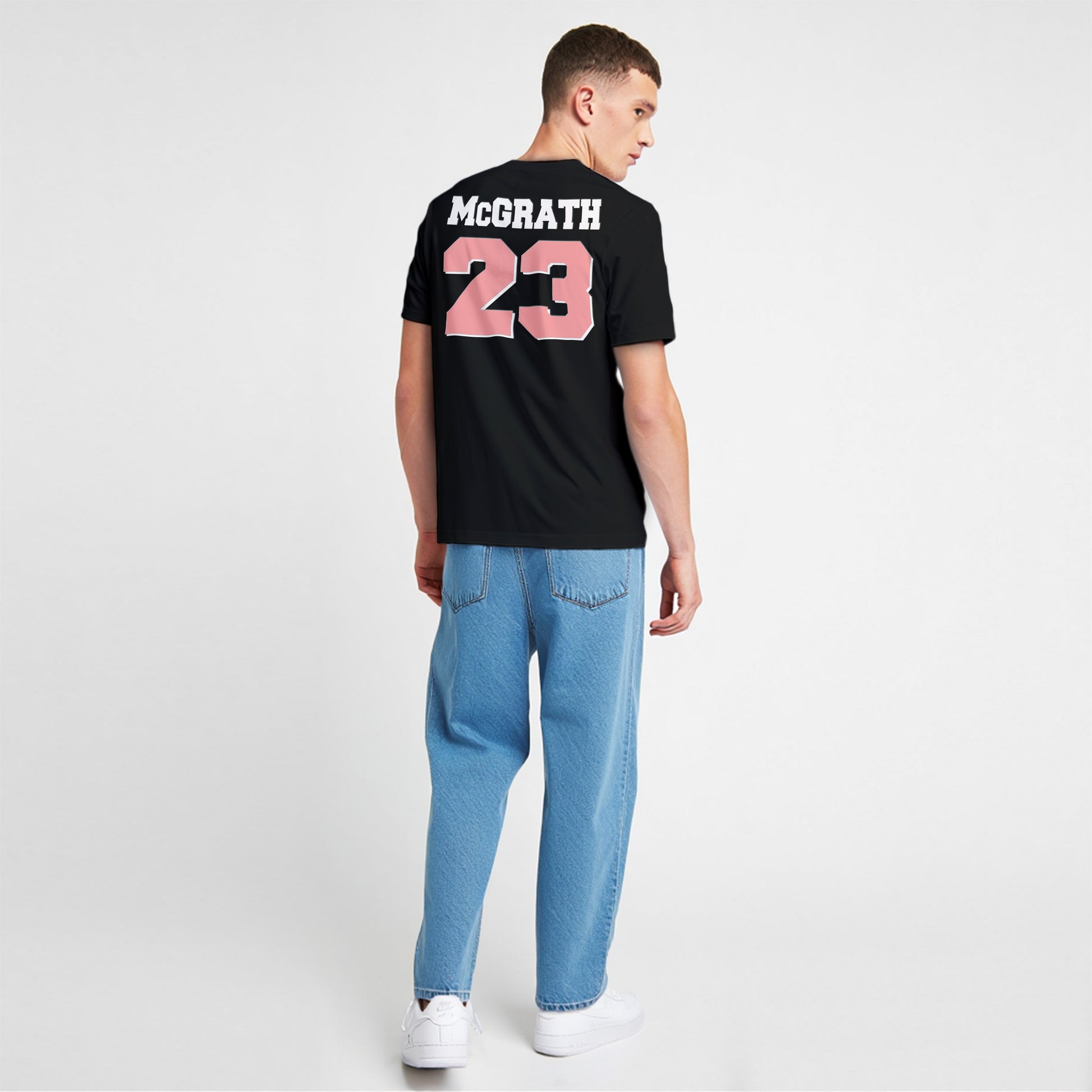 Person wearing a black t-shirt with 'McGrath 23' on the back, standing against a white background.