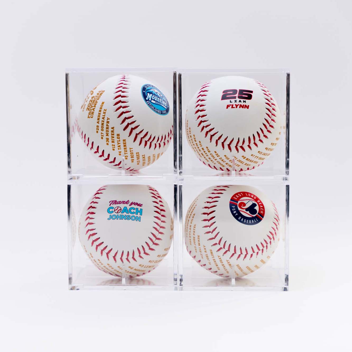 Four baseballs with different logos in clear display cases
