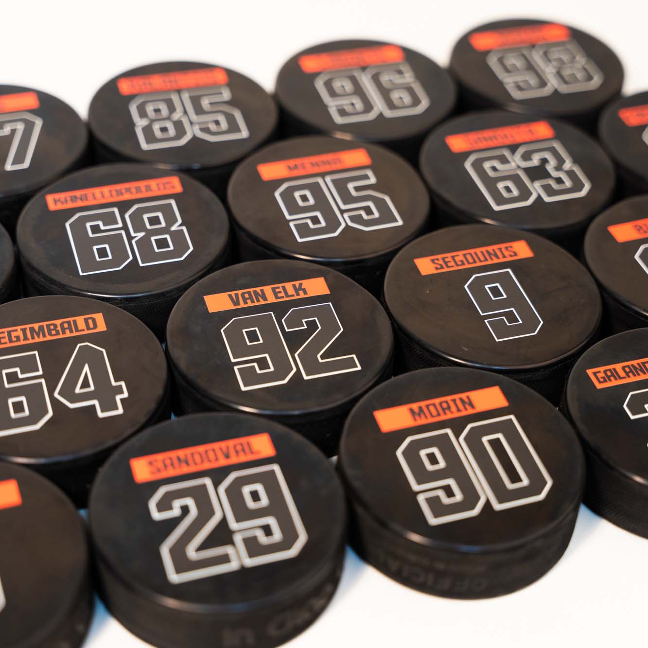 custom printed bulk hockey pucks with player names and numbers