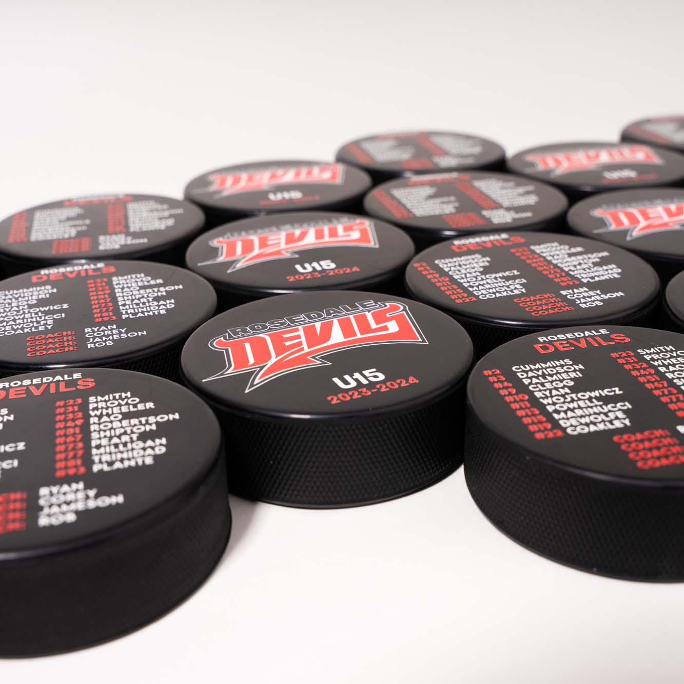 Customized hockey pucks with team logo and roster