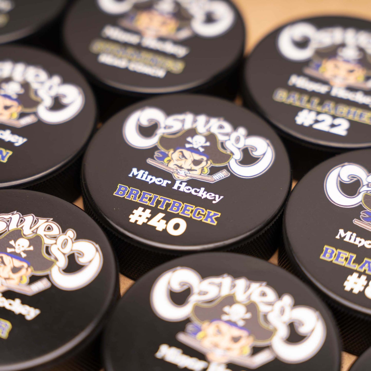 Collection of hockey pucks with team logo, player names and numbers