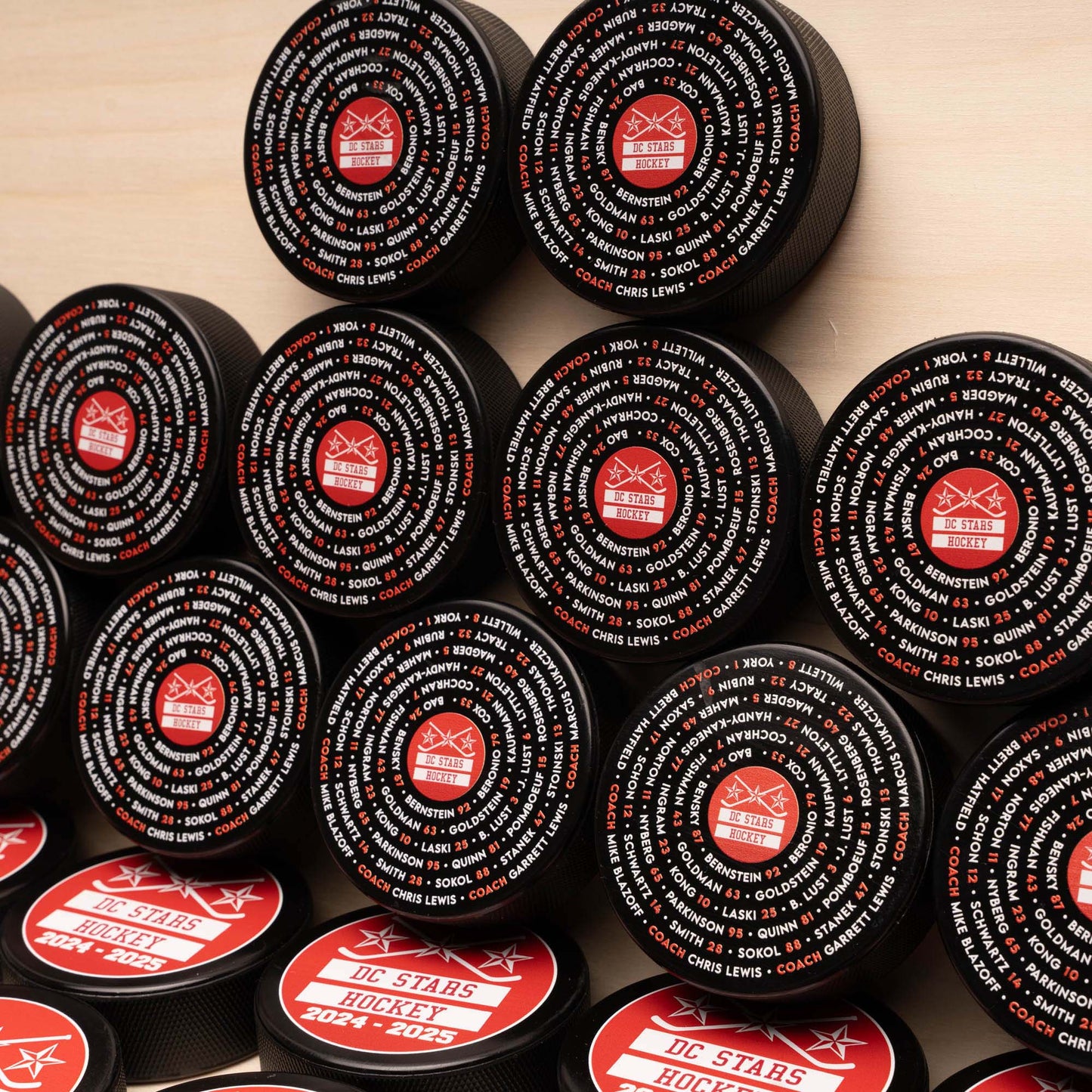 Multiple hockey pucks with concentric roster and team logo