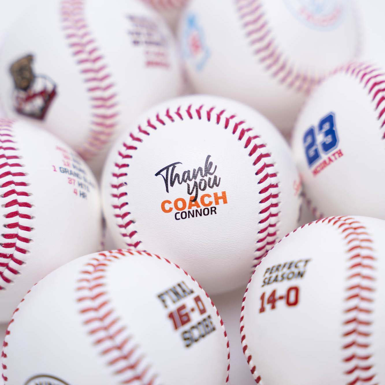 Baseballs with thank you coach messages and numbers on a close-up shot