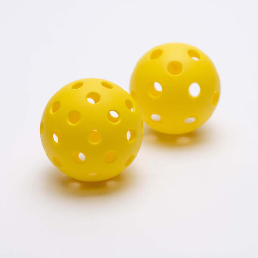 Two yellow pickleballs