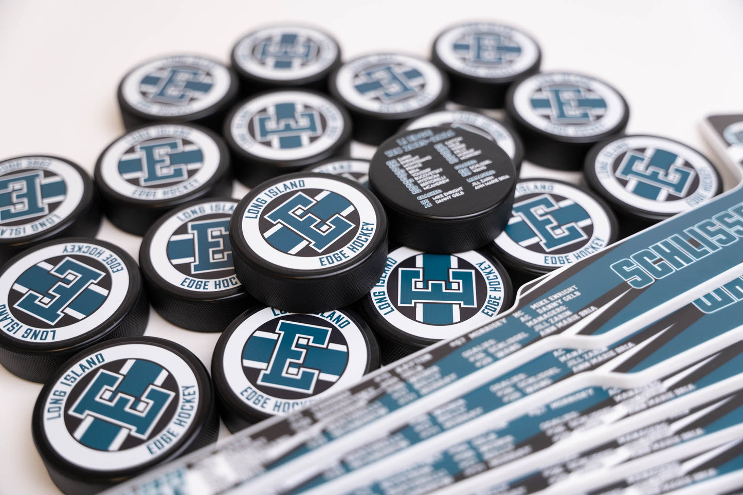 Collection of hockey pucks with logos on a white background