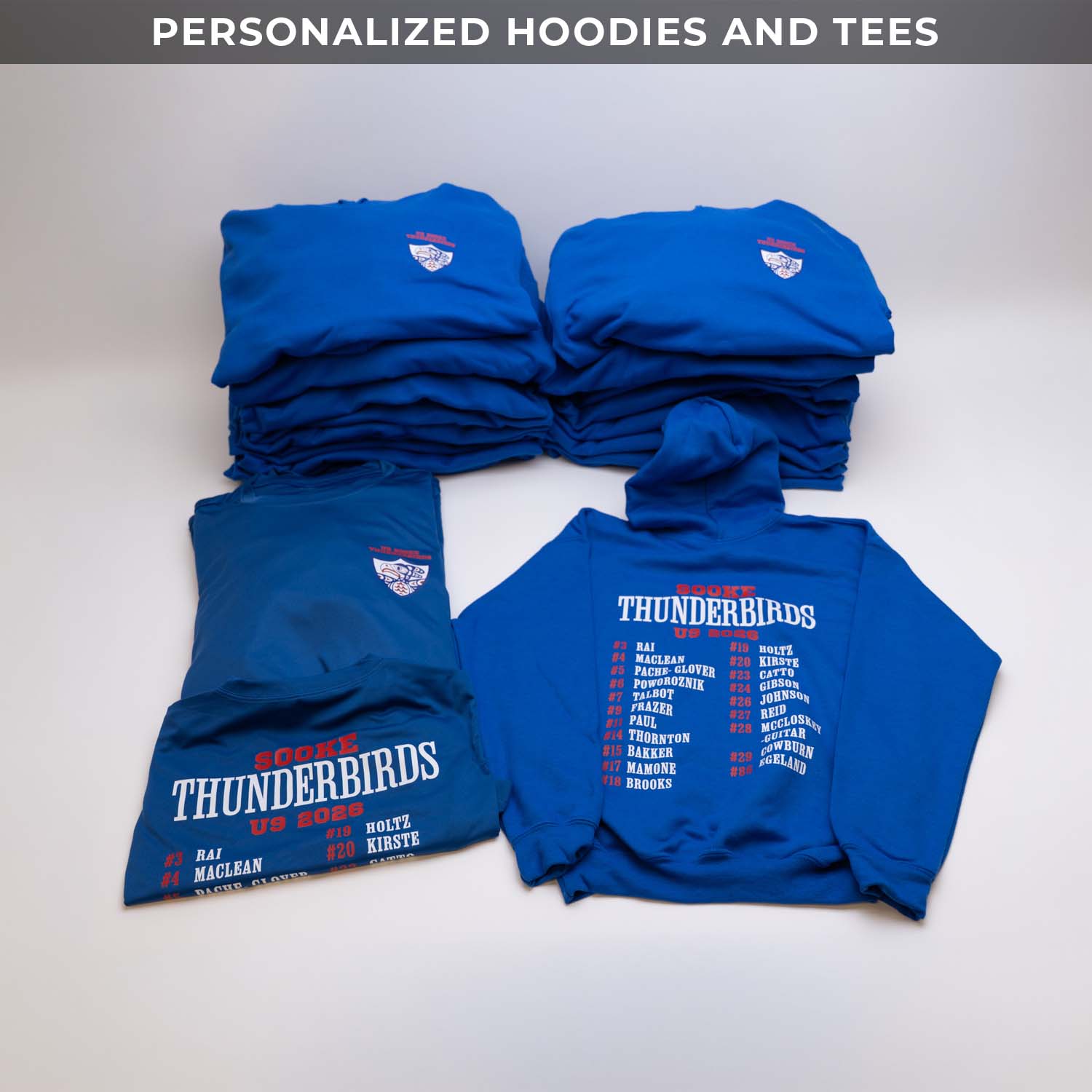 Stack of blue hoodies and tees with 'Thunderbirds' text on a white background