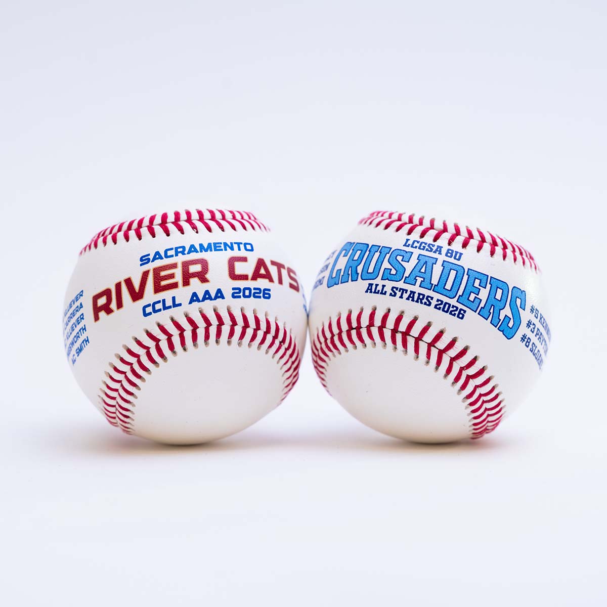 Two baseballs with 'Sacramento River Cats' and 'LCOSA Crusaders' text on a white background