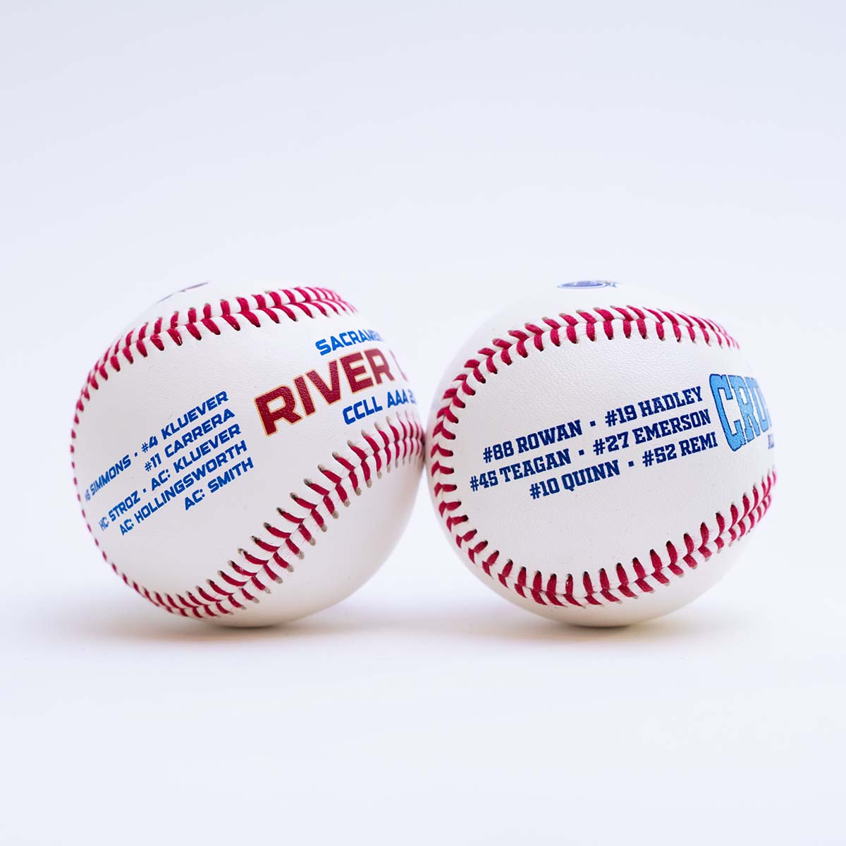 Two baseballs with text and logos on a white background