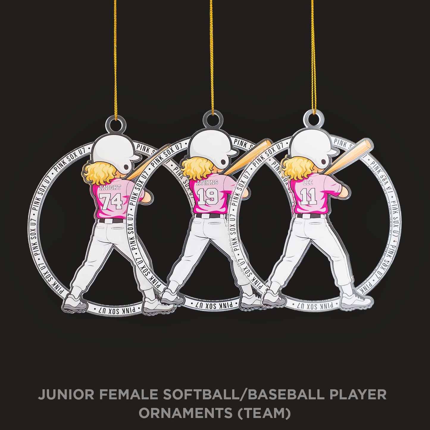 Three softball/baseball player ornaments hanging against a black background